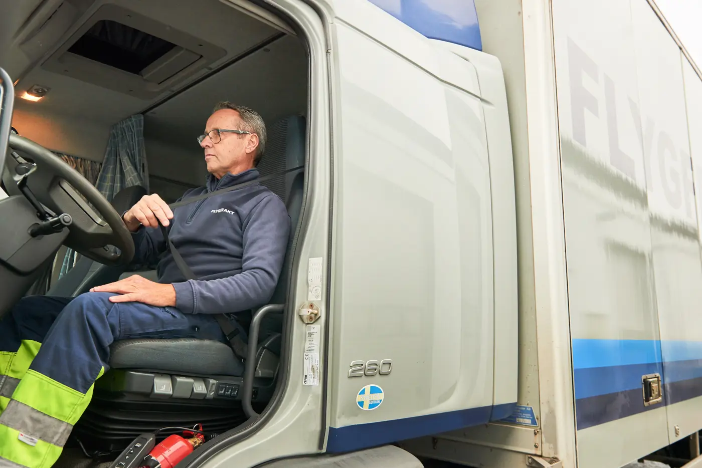 En förare sitter i en lastbilshytt