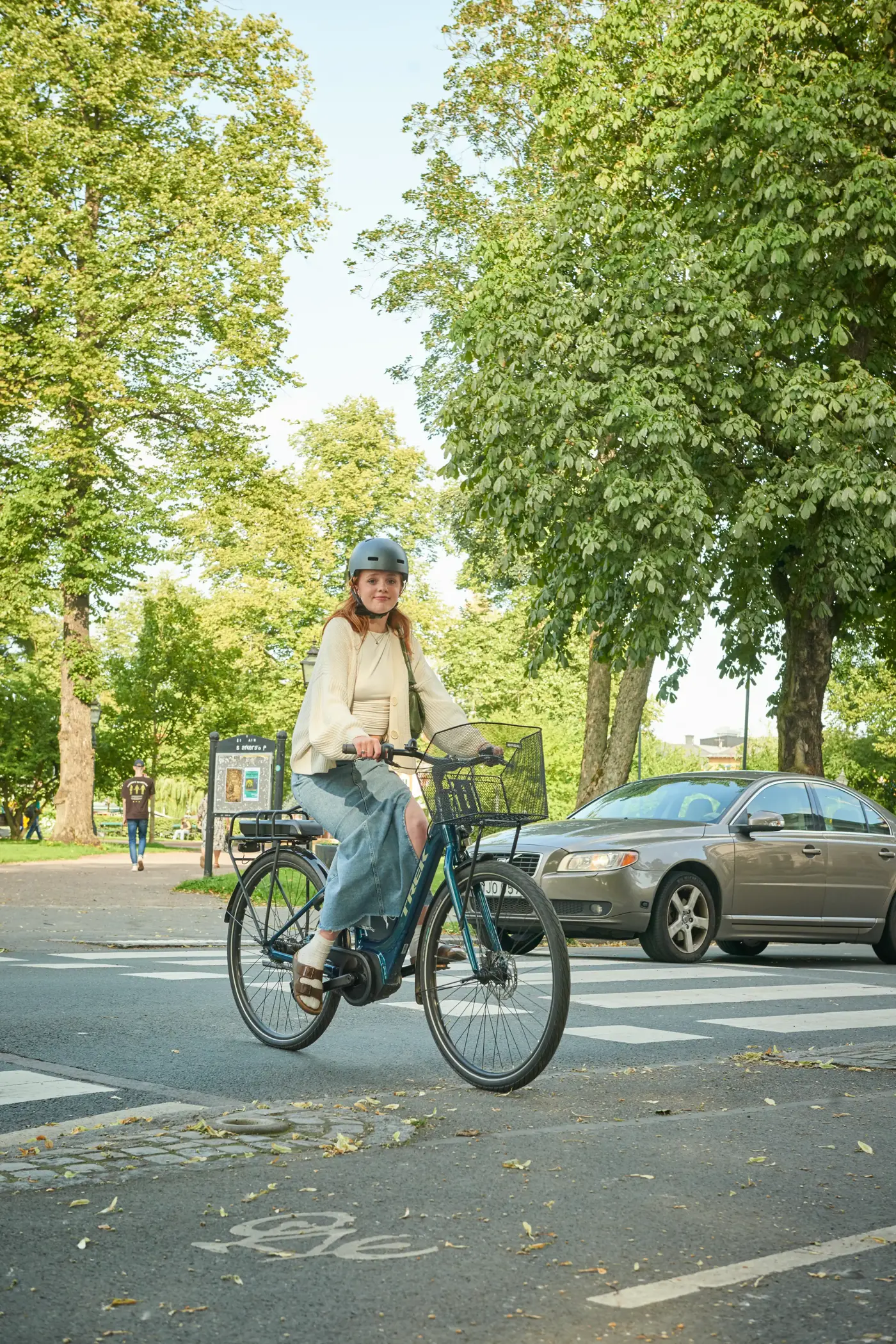 Ung kvinna som cyklar över en cykelpassage