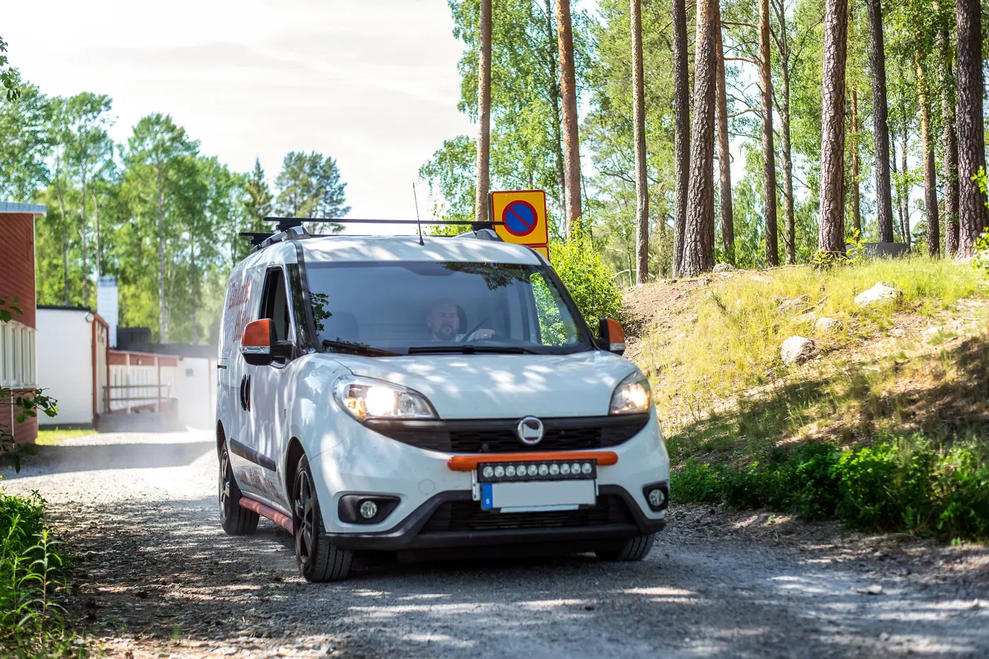 En person kör en skåpbil på en grusväg.
